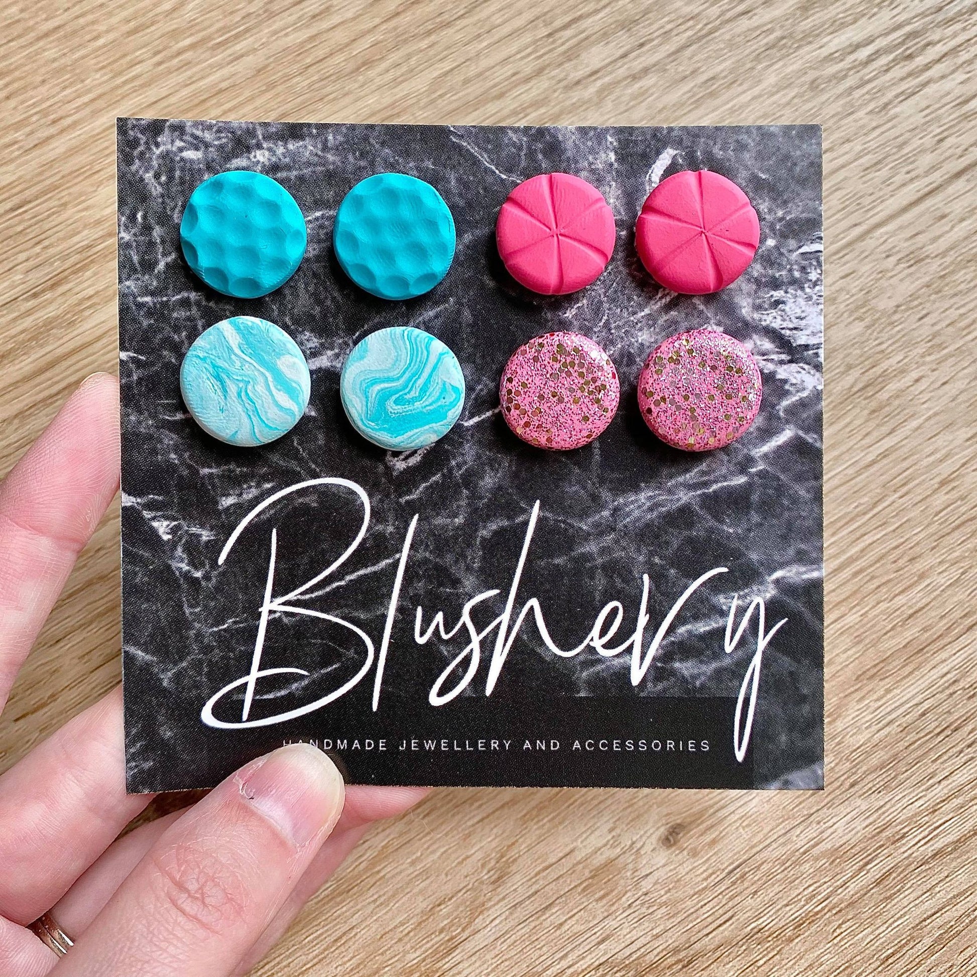 polymer clay stud earrings in bright teal and pink colours and textures