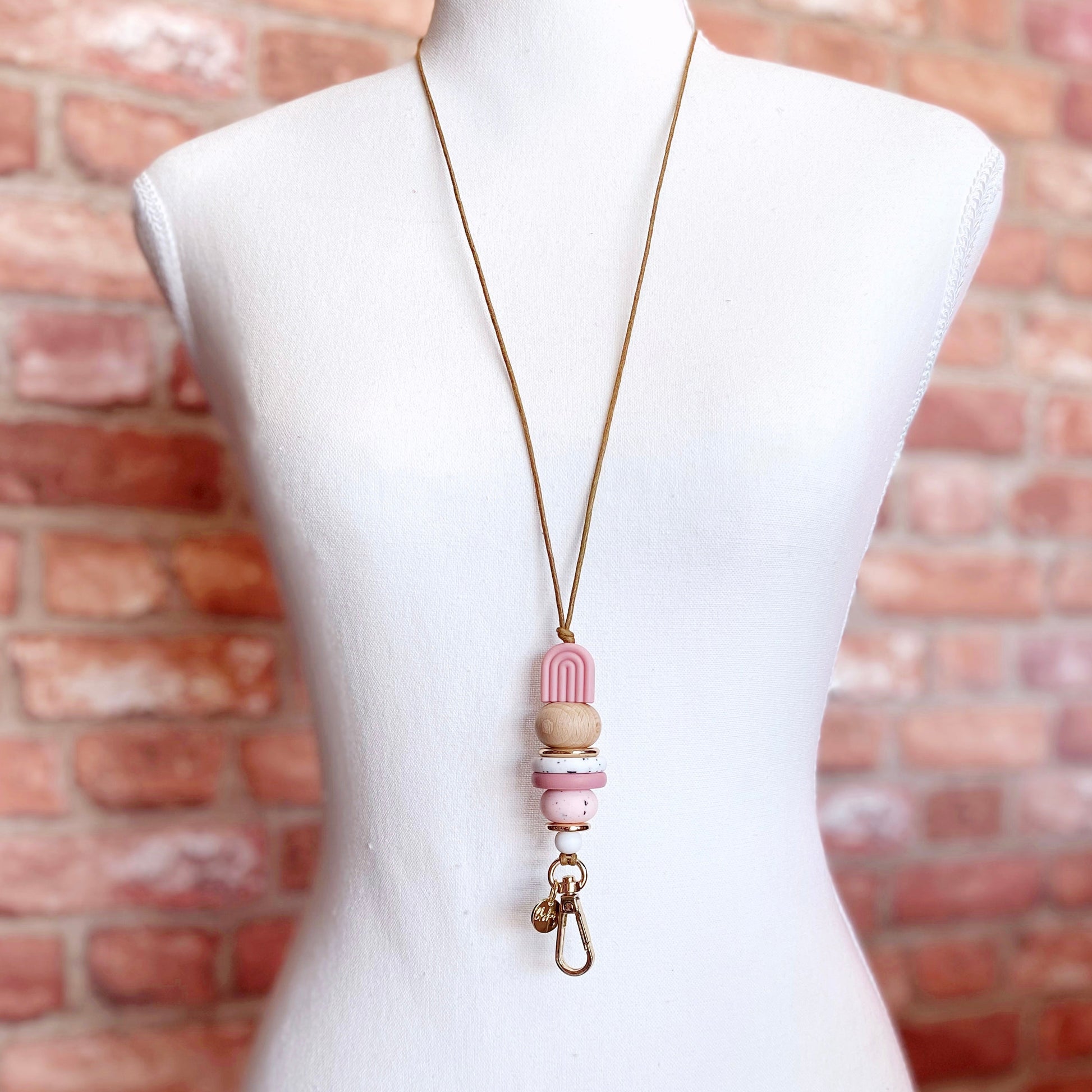 natural pink rainbow design on display model showing brown waxed cord and gold plated clasp