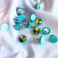 up close to the teal handmade polymer clay push pins, showing beautiful detail