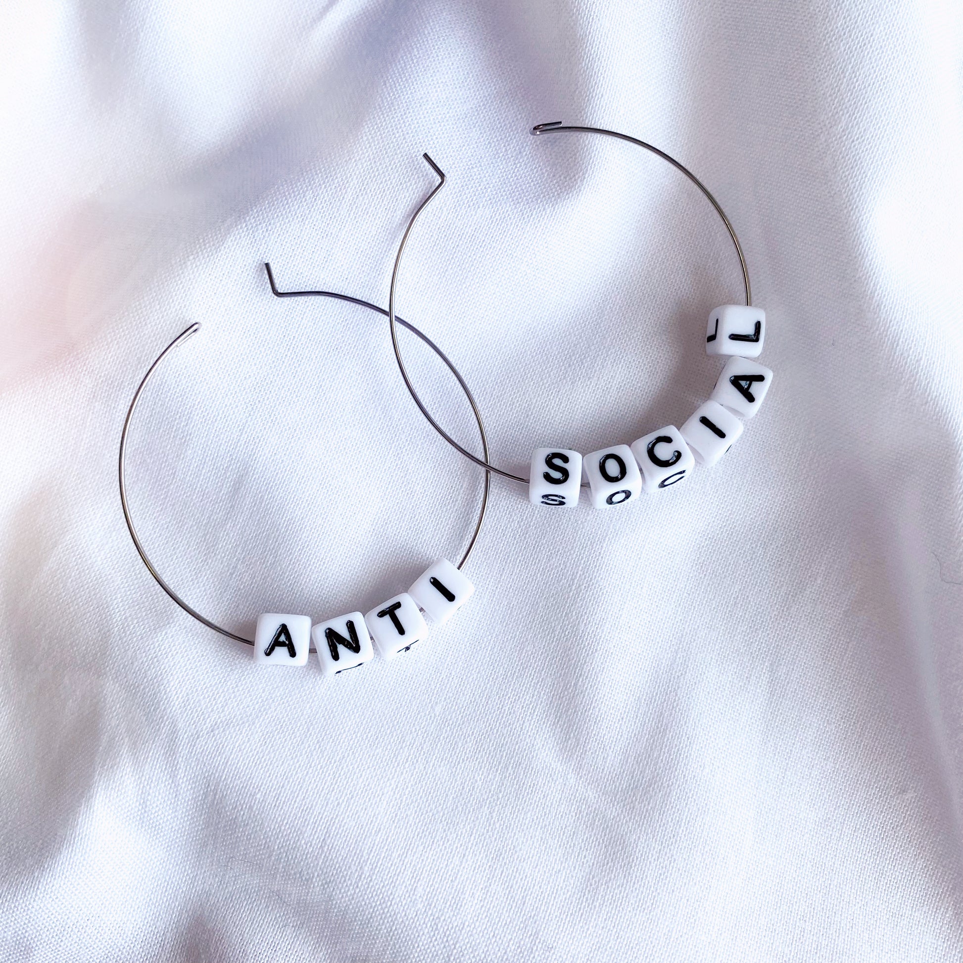 available on a gold or silver hoop, these earrings are funny and silly with the words anti-social