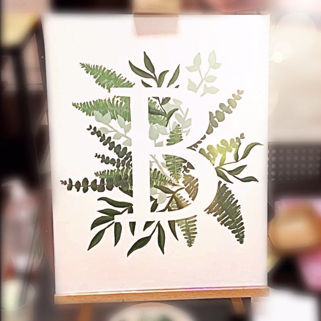 beautiful leaves painted behind a large customisable letter on canvas