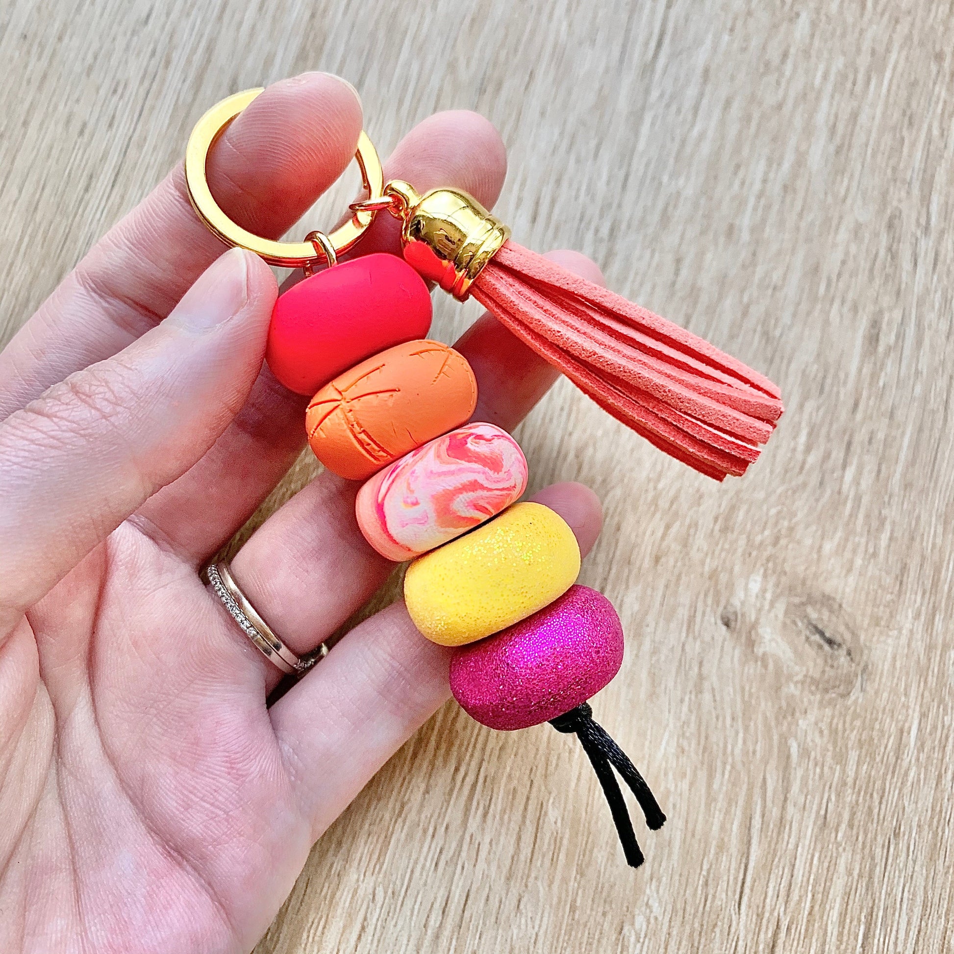 polymer clay beaded keychain, inspired by a tropical sunset with pink purple orange and yellow colours