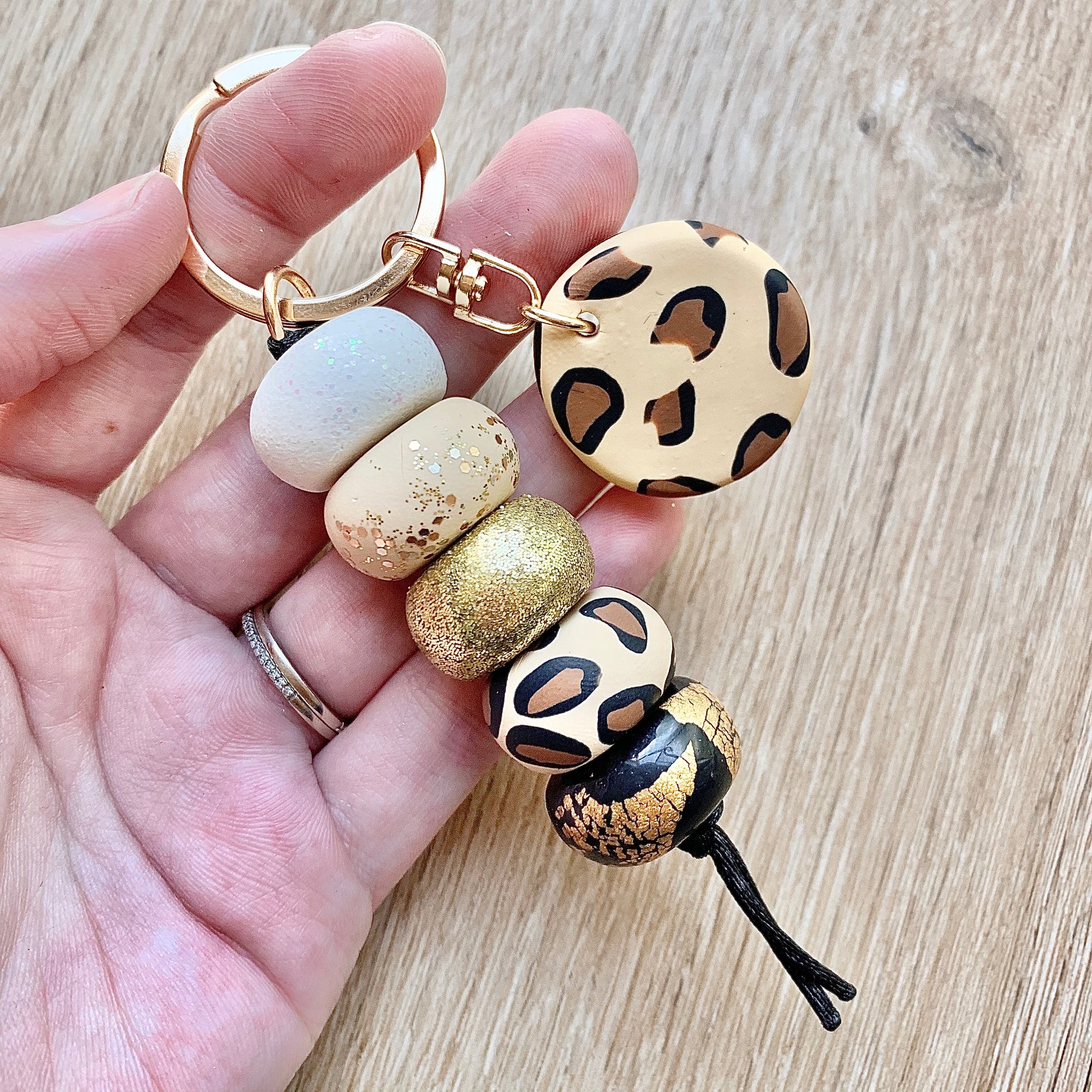 beaded polymer clay keychain in neutral gold white and black colours with a leopard print accent