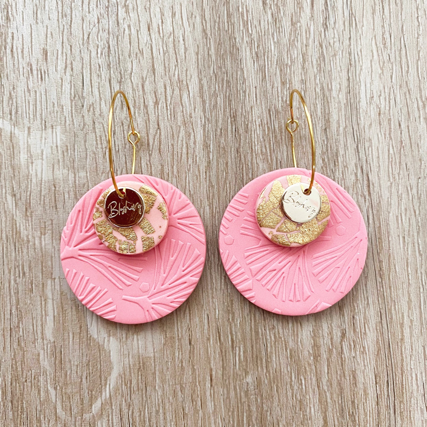 3 round discs on a hoop earring in coral pink and gold
