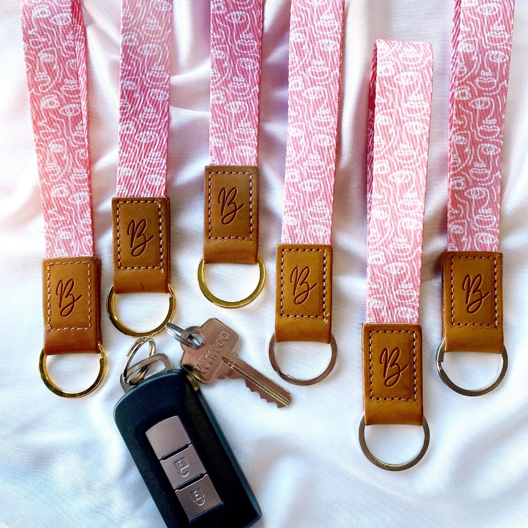 pink wristlet keychain with abstract faces